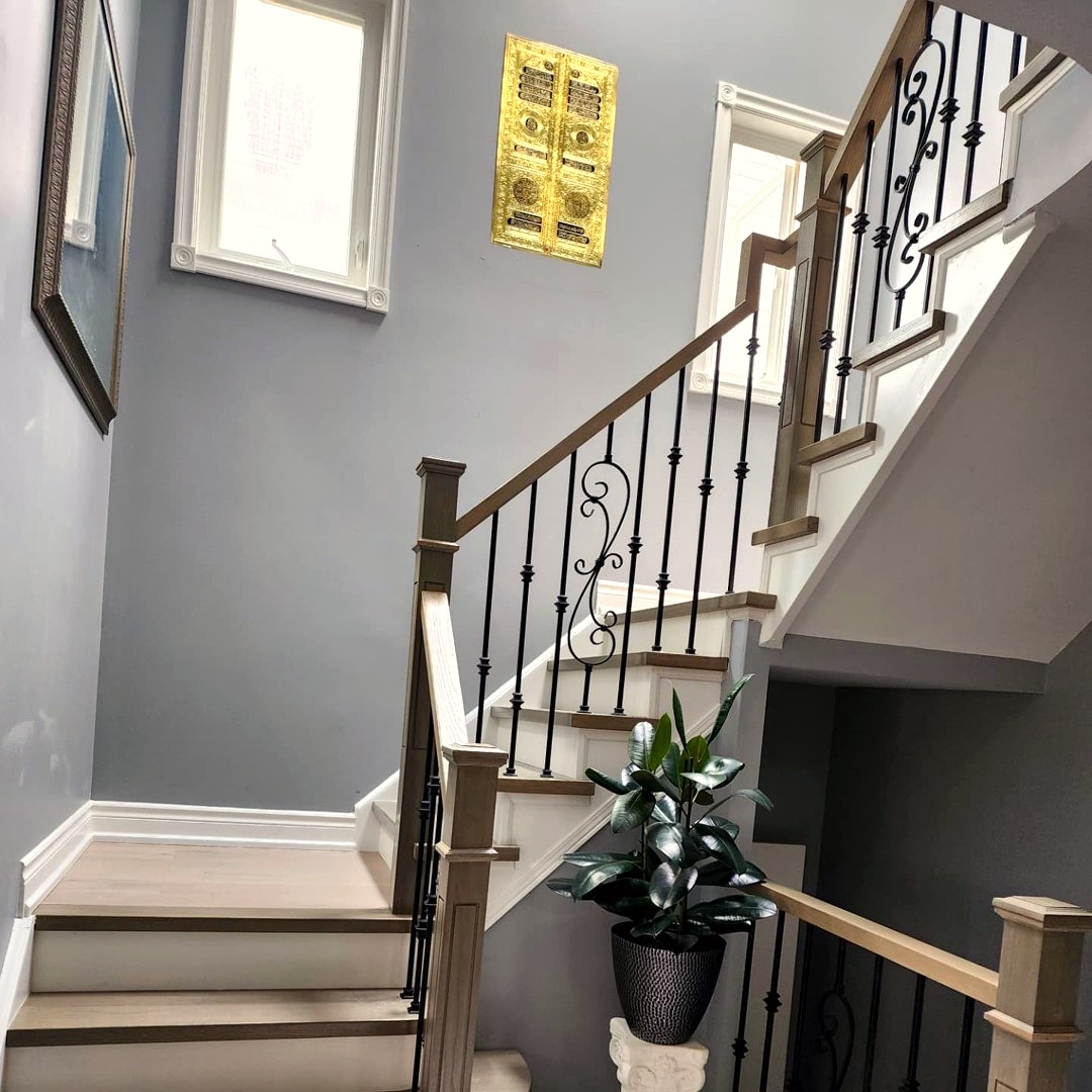 Curved staircase with wrought iron spindles and stained oak handrail