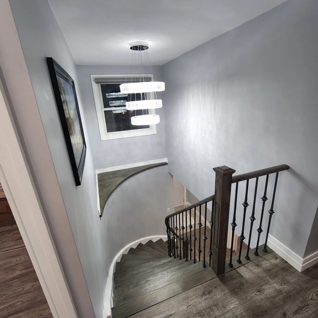 Elegant primary bedroom with sage feature wall, white oak nightstands and soft neutral bedding in Whitby, Ontario